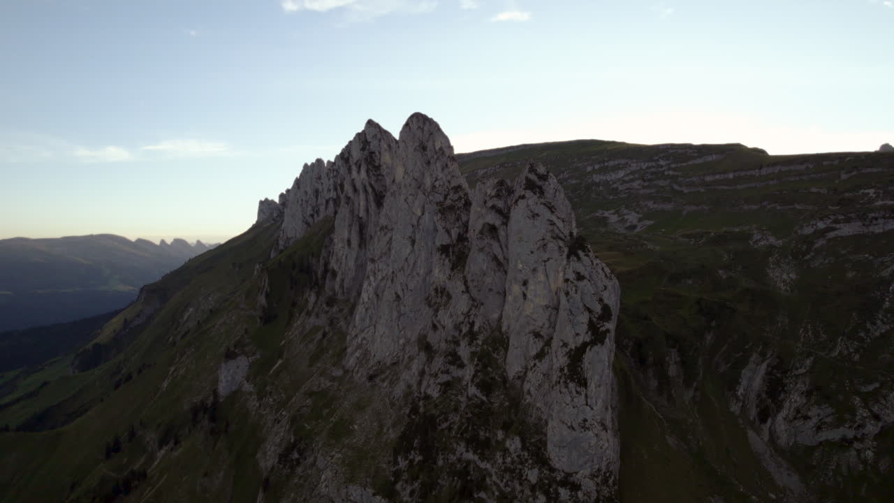 Volteggiando attorno a una montagna rocciosa svizzera al tramonto, estate