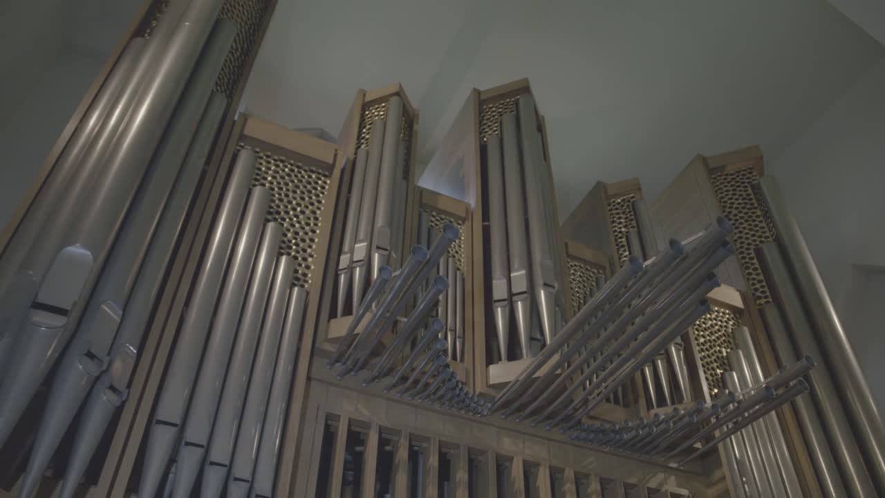 Camera panning along large organ with large organ pipes in a church