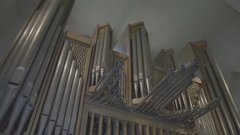 camera panning along large organ with large organ pipes in a church