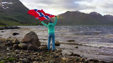 Frau-Mit-Einer-Wehenden-Norwegischen-Flagge-Auf-Dem-Hintergrund-Der-Natur