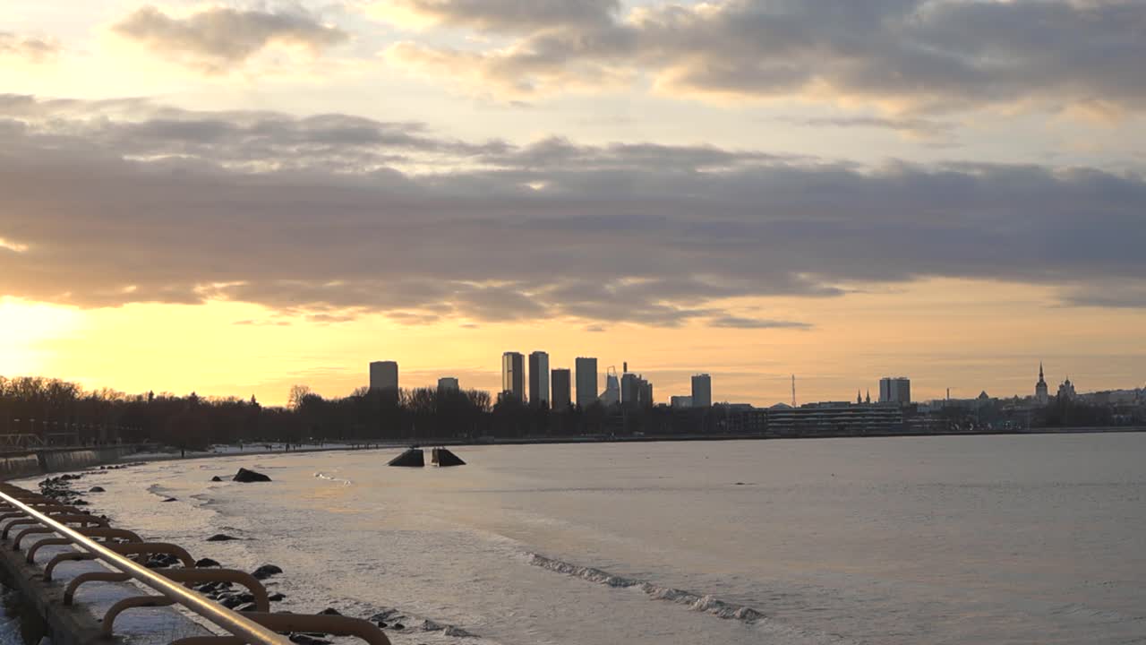 황금색 노란색과 오렌지색의 해가 지거나 해가 뜨는 린 시의 영상, 아침 어두워지거나 밤 저녁, 하늘에 구름이 있는 겨울의 시간, 오른쪽에 발트해가 있는 피리타 해변에서 촬영된 영상.