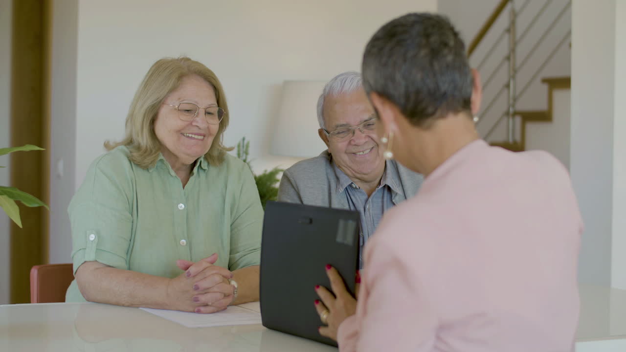새 집에서 행복한 노부부에게 열쇠를 주는 부동산업자