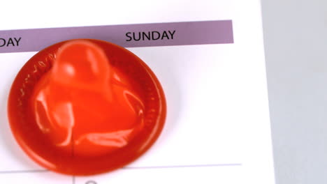el condón cayendo en un calendario.