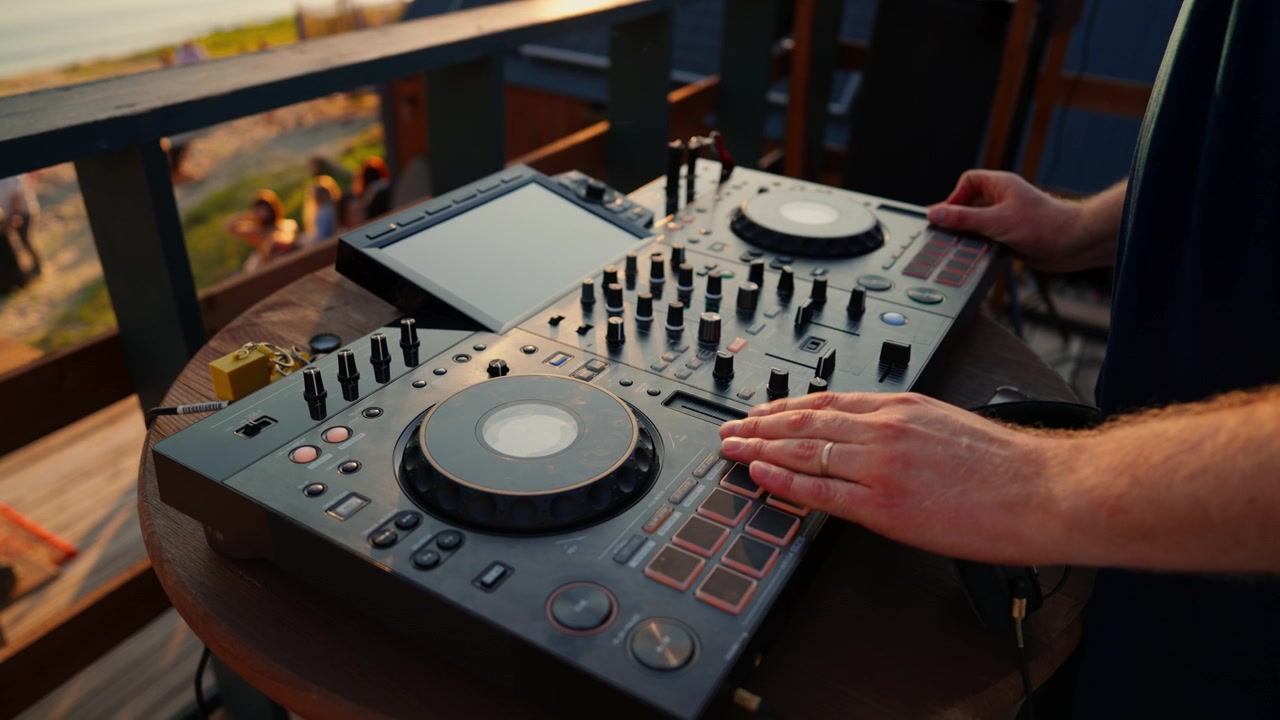DJ Mixing Music on Controller at Outdoor Beach Party