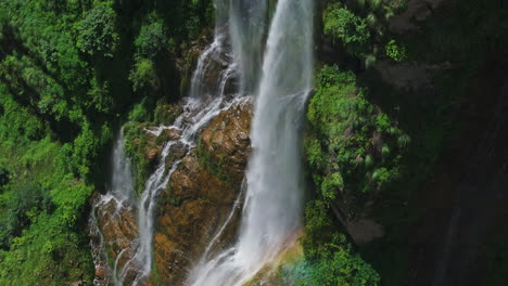 rainbow reveals its vibrant colors over waterfall on huge cliff in lush greenery of nepal peaceful escape o nature beauty and importance of earth protection in nepali tourism drone shot