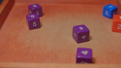 rol de cubo colorido jugando dados rodando sobre superficie de madera, cámara lenta