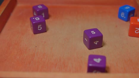 colorful cube role playing dices rolling on wooden surface, slow motion