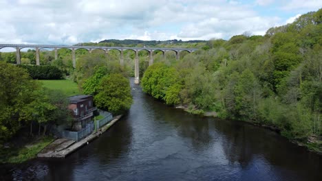 aerial view pontcysyllte aqueduct and river dee canal narrow boat bride in chirk welsh valley countryside low descend