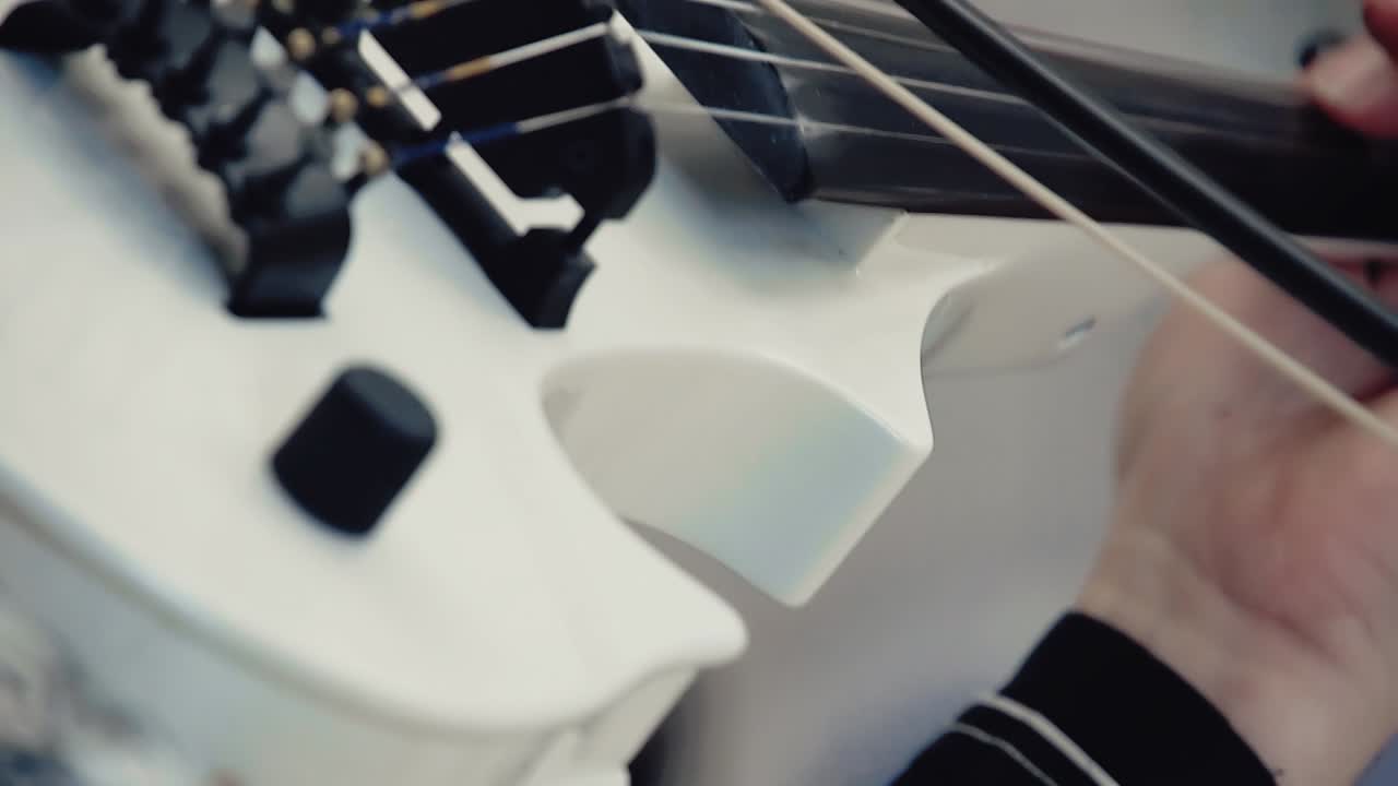 violín blanco en las manos en un concierto