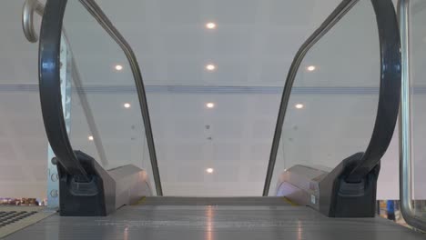 cerca, la parte superior de una escalera mecánica en movimiento en el aeropuerto