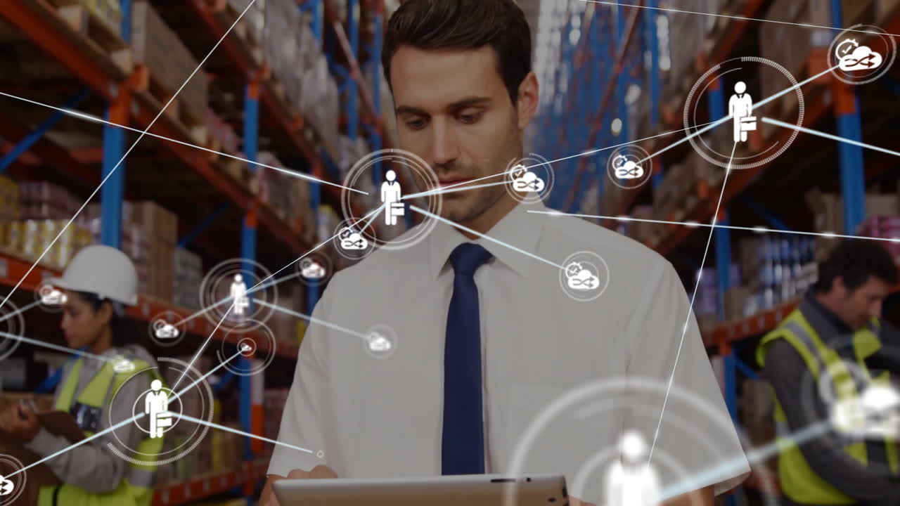 Using tablet with network connections, businessman in warehouse setting