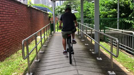 chinese man cycling on covered pathway