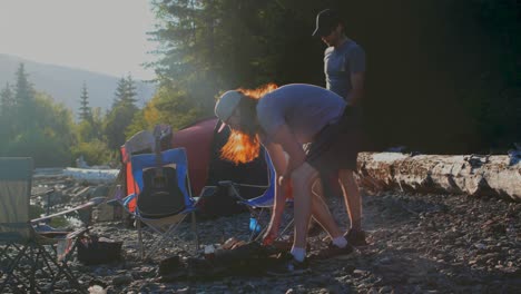 hombres preparando fuego de campamento cerca de la orilla del río 4k