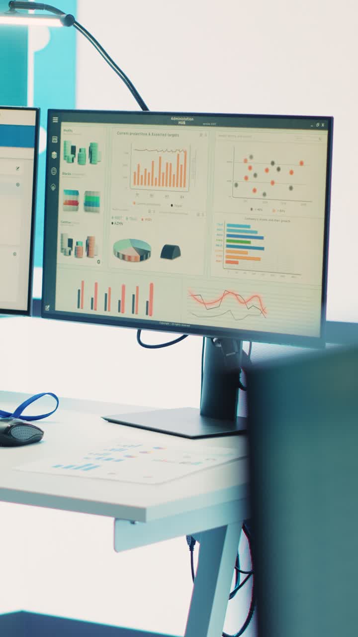Office Desk with Dual Computer Monitors Displaying Business Data
