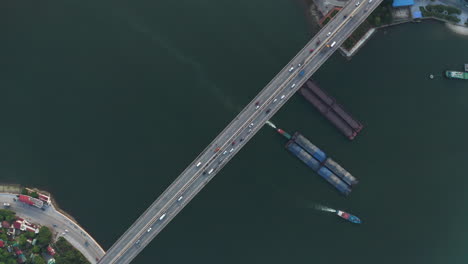 long suspension bridge above shipping lane - top down aerial drone shot