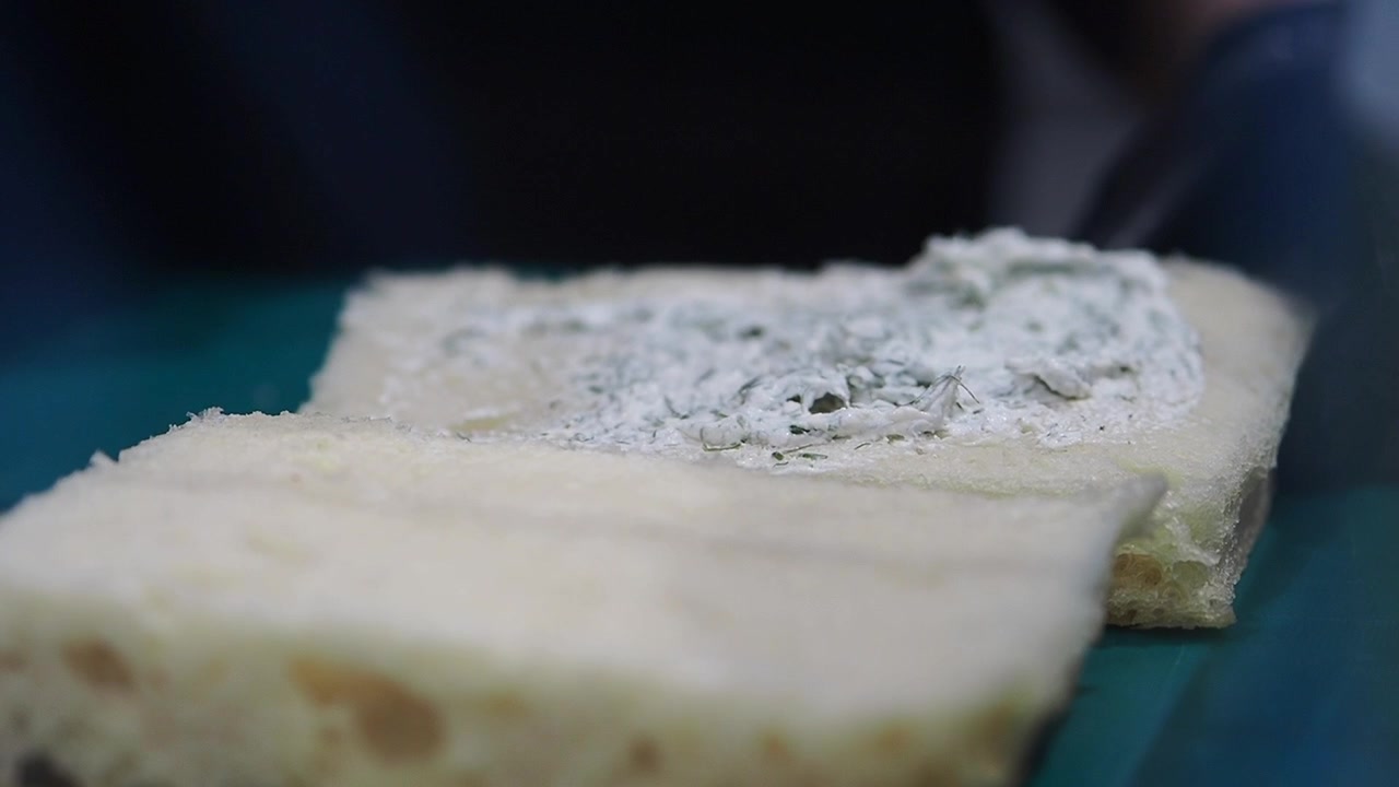 Chef Spreading Cream Cheese on Bread Slice
