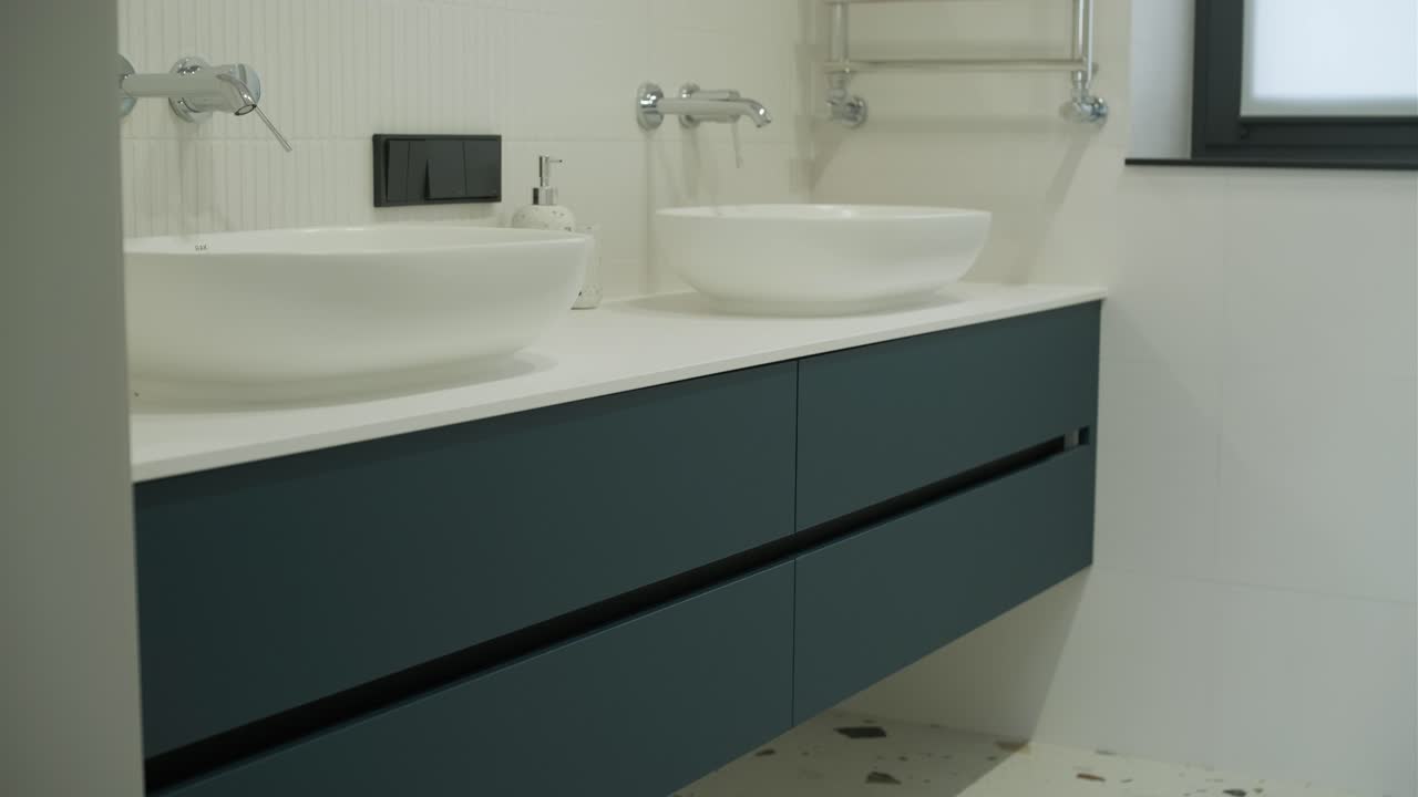 Baño moderno alicatado con ducha en un hogar moderno, interior inmobiliario. Metraje de plano amplio