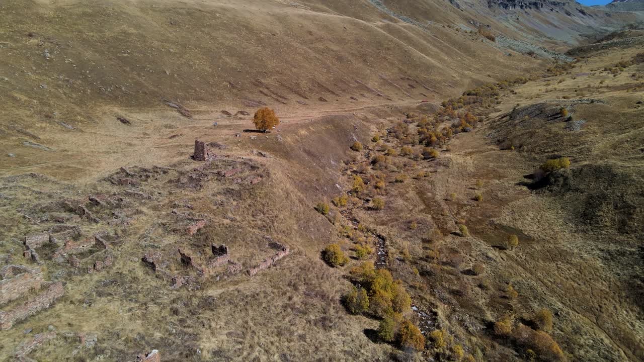 antiguas ruinas en un valle de montaña durante el otoño