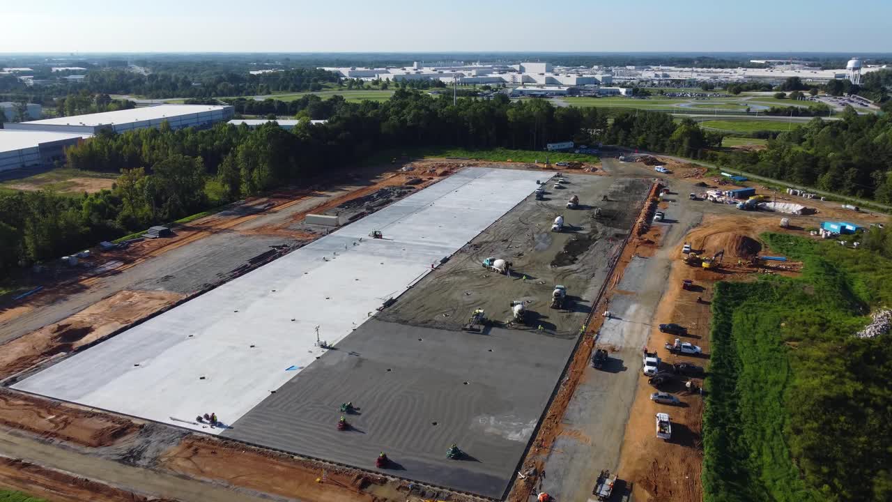 un dron vuela sobre una plataforma de hormigón medio vertida en un sitio de construcción