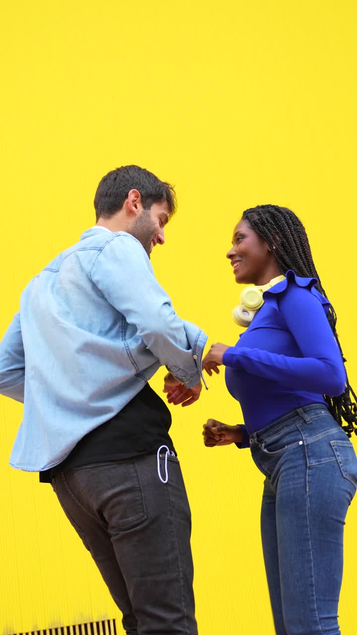Two People Dancing in Front of Yellow Wall