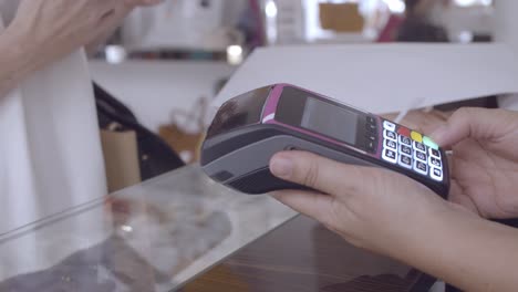 cliente que usa un teléfono inteligente para pagar en la tienda