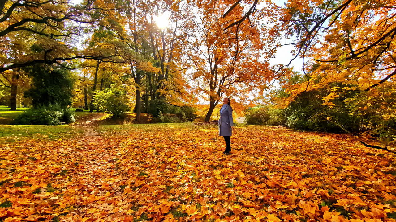 Woman in autumn leaves at Lielvārdes Hill, feeling peace