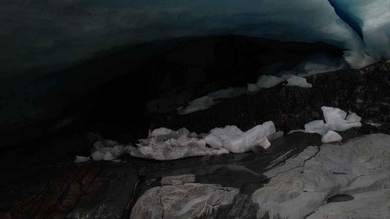 drone revelando una cueva de hielo debajo del glaciar brewster derritiéndose en el río