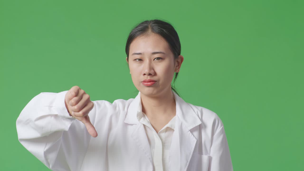 실험실 코트를 입은 여성이 엄지손가락을 내려놓습니다.