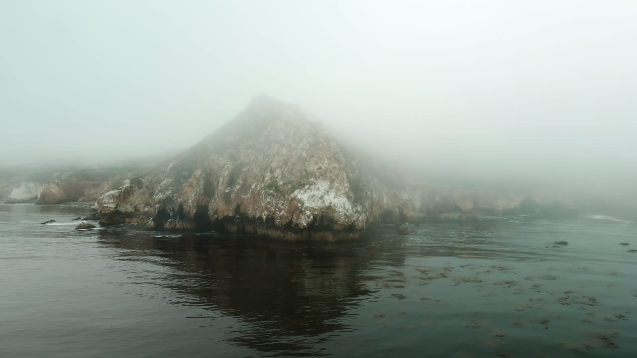 vuela sobre el océano con un acantilado épico en la costa de california en un día de niebla