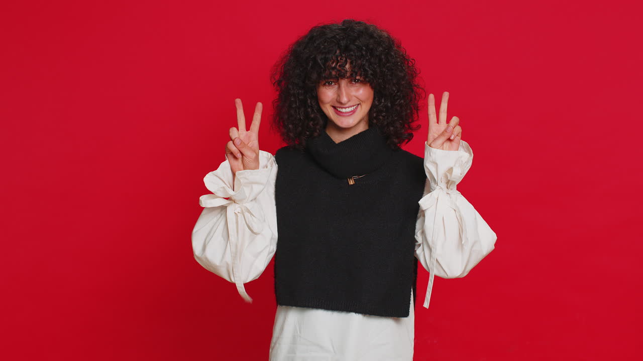 feliz mujer joven sonriente mostrando señal de victoria, con la esperanza de éxito y ganar, haciendo gesto de paz