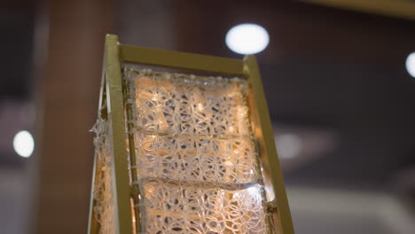 close-up of intricate gold frame with detailed pattern illuminated by warm glowing light, creating a festive and elegant ambiance, blurred background with circular bokeh