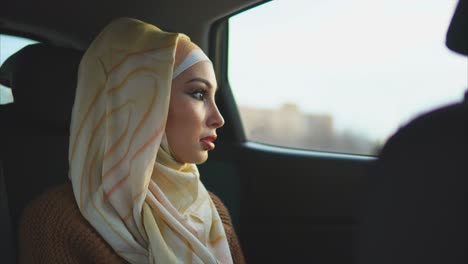 woman in hijab sitting in a car