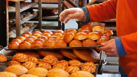 bakery worker displaying fresh bread and pastries
