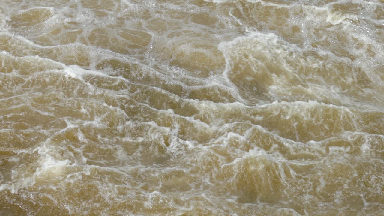 Raging and frothy water of the Ottawa River as it pours down stream from the Hydro Dam off of Chaudière Island in Ottawa, Ontario, Canada