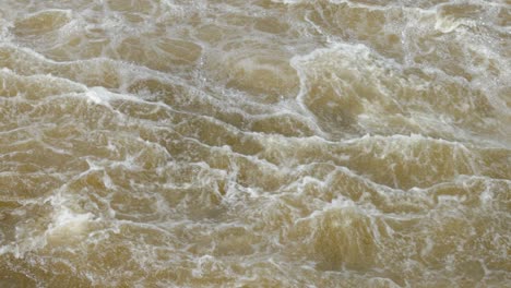 raging and frothy water of the ottawa river as it pours down stream from the hydro dam off of chaudière island in ottawa, ontario, canada