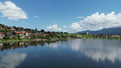 Lago-Hopfensee-Y-Ciudad-Hopenfen-Suabia-Baviera-Alemania-Empuje-En-Vista-Aérea-De-Drones