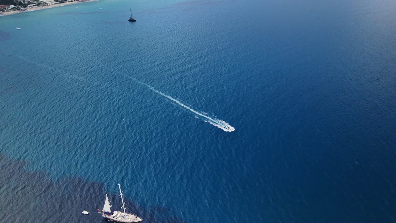 Vista aerea di una barca che naviga su un mare blu calmo, evocando libertà e avventura