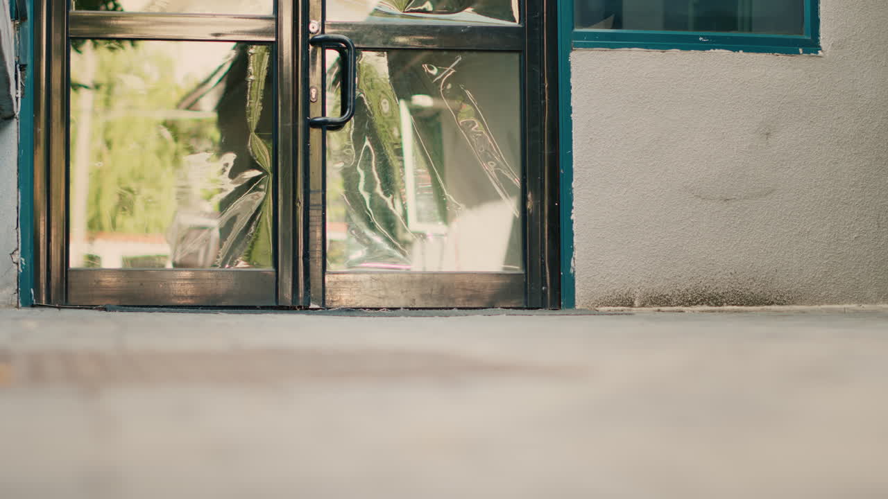 Person picking up brown paper bag near door