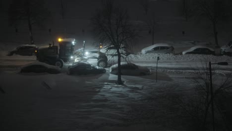 snow clean vehicle passes parked cars during winter evening