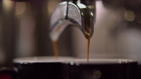 Aus-Der-Nähe-Ist-Ein-Metallischer-Doppelauslauf-Zu-Sehen,-Aus-Dem-Espresso-In-Zwei-Separate-Espressotassen-Aus-Glas-Fließt