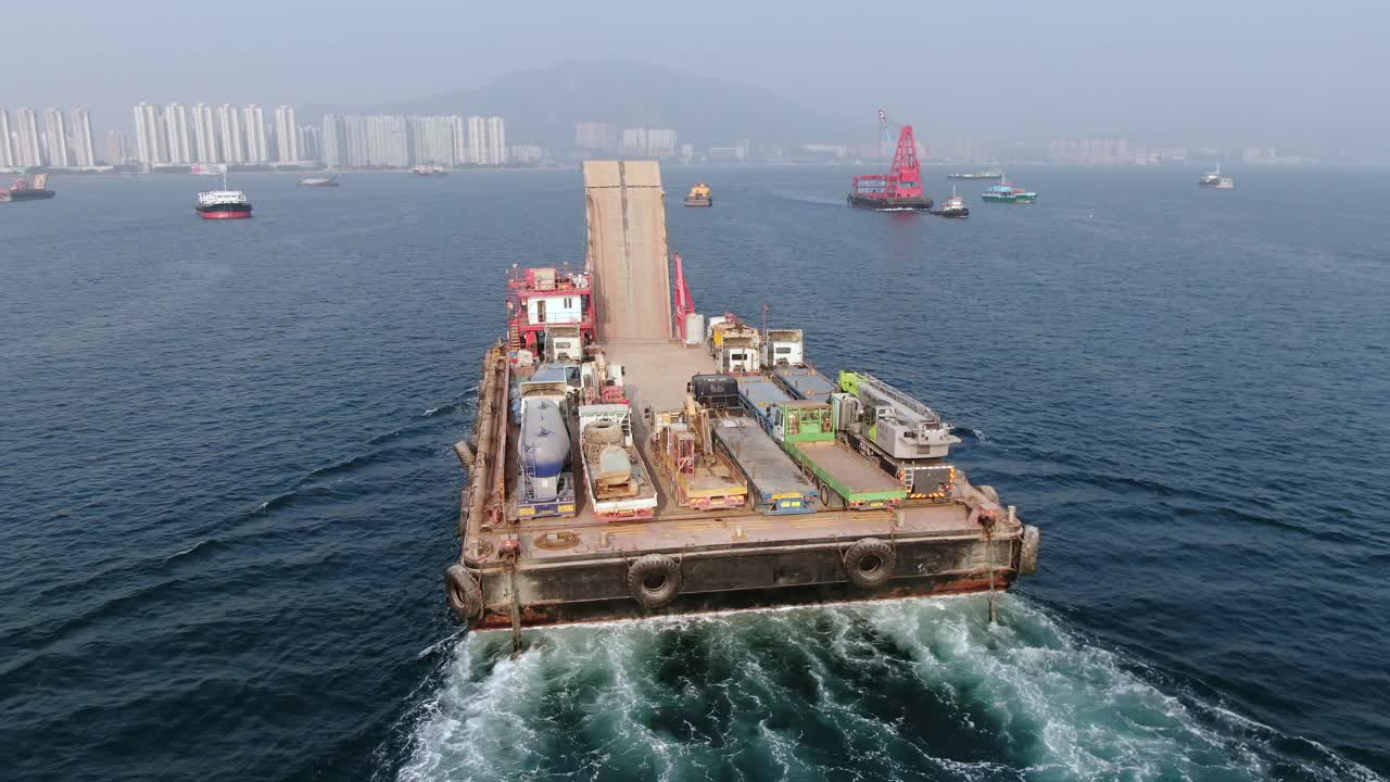 홍콩 만의 예인선으로 항구로 끌려간 콘크리트 믹서 트럭을 실은 바지선, 공중 전망