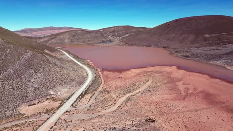 aerial descends to red, muddy laguna llajuapampa in peru foothills