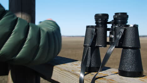 hand of an ornithologist resting his binocular