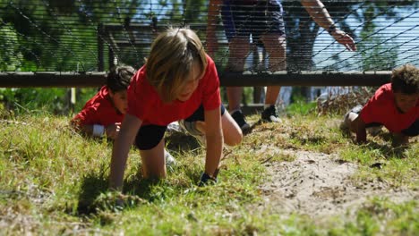 kids crawling under the net during obstacle course training