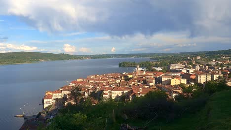 beautiful wide-angle timelapse of moving clouds over arona city and maggiore lake in italy