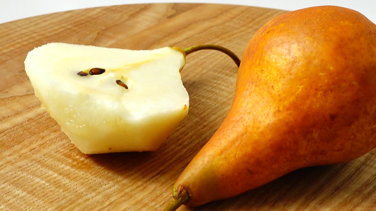 Pere su un tagliere di legno in cucina. Ripresa in movimento