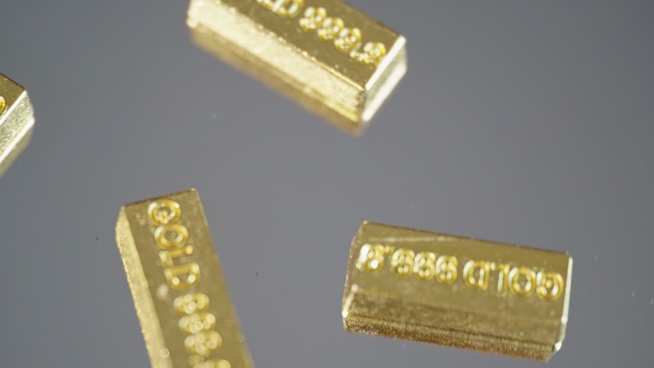 múltiples pequeñas barras de oro estampadas 999,9 giran en una superficie de espejo circular, simbolizando riqueza, valor y lujo