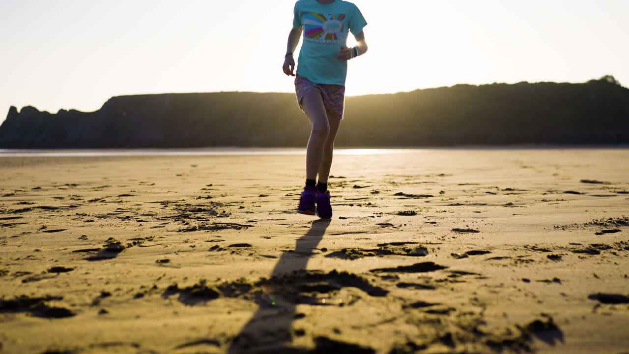 해가 지면 해변에서 달리는 소녀