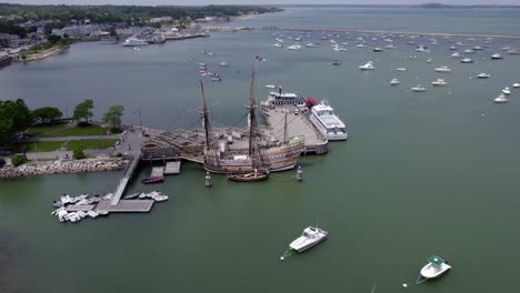 aerial view away from the mayflower ii schooner docked in plymouth, usa - pull back, tilt, drone shot