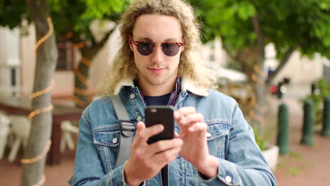 Young-happy-man-laughing-and-using-a-phone-to-read